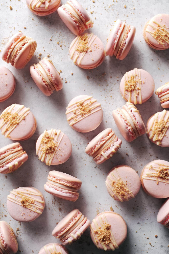 strawberry cheesecake macarons with smooth, glossy shells and creamy strawberry cheesecake filling in the center
